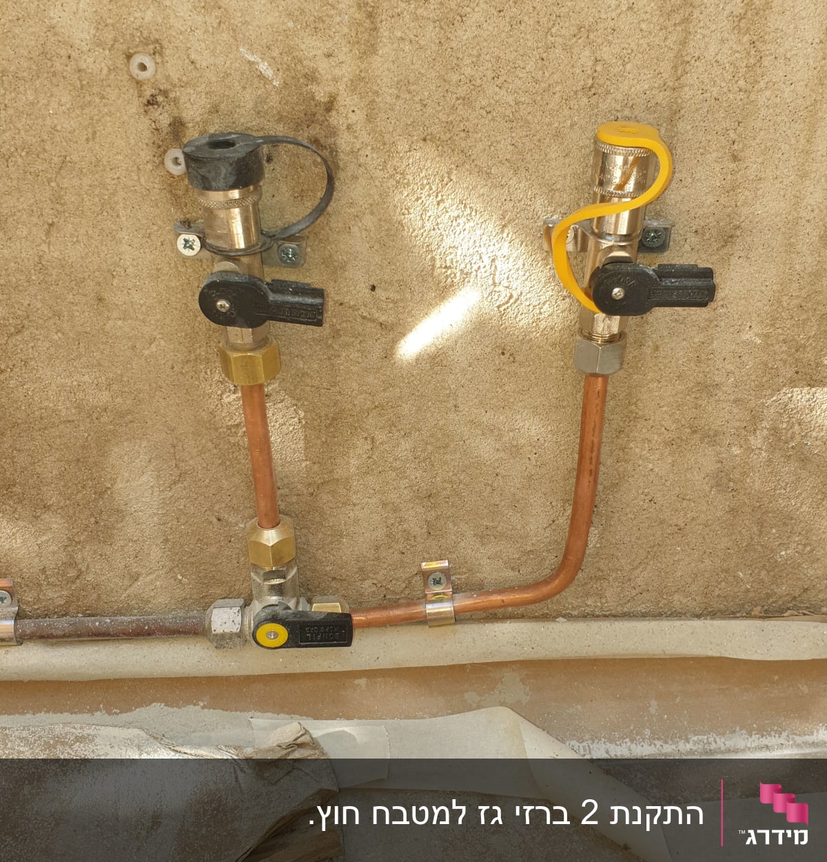צינורות גז עם ברזים ומחברים על קיר